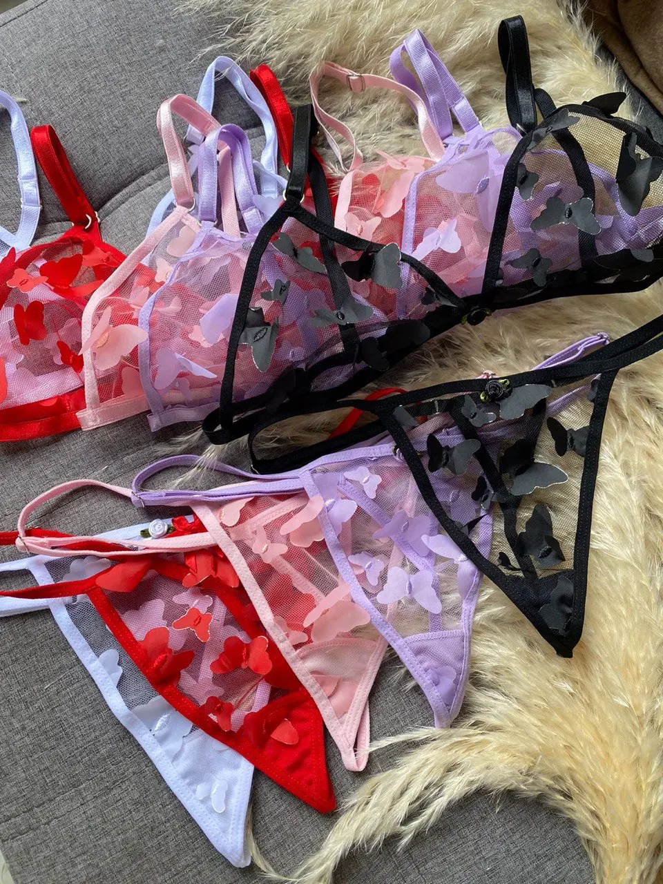 Conjuntos de lencería femenina sin varillas en colores rojo, rosado, morado y negro con apliques decorativos de mariposas.