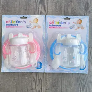 Dos sets de vajilla infantil de cuatro piezas en empaque plástico, uno rosa y otro azul, cada uno incluye plato, vaso antiderrame, cuchara y tenedor.