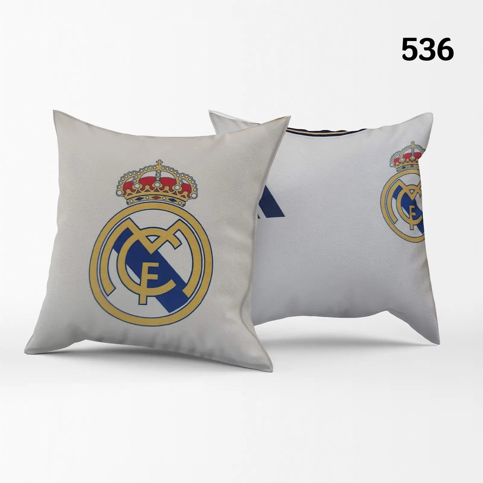 Dos fundas para cojines decorativos de fútbol en color gris claro con el escudo del Real Madrid impreso.