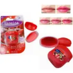 Bálsamo labial hidratante de fresa en tarro rojo, incluye empaque original, muestra textura del producto y efecto de color brillante en labios.