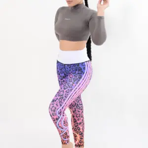 Crop top deportivo gris de manga larga y cuello alto, combinado con leggins estampados de leopardo en tonos morado y fucsia.