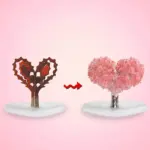 Proceso de crecimiento de árbol de cristales en forma de corazón: de estructura marrón a cobertura de cristales rosados sobre base blanca.