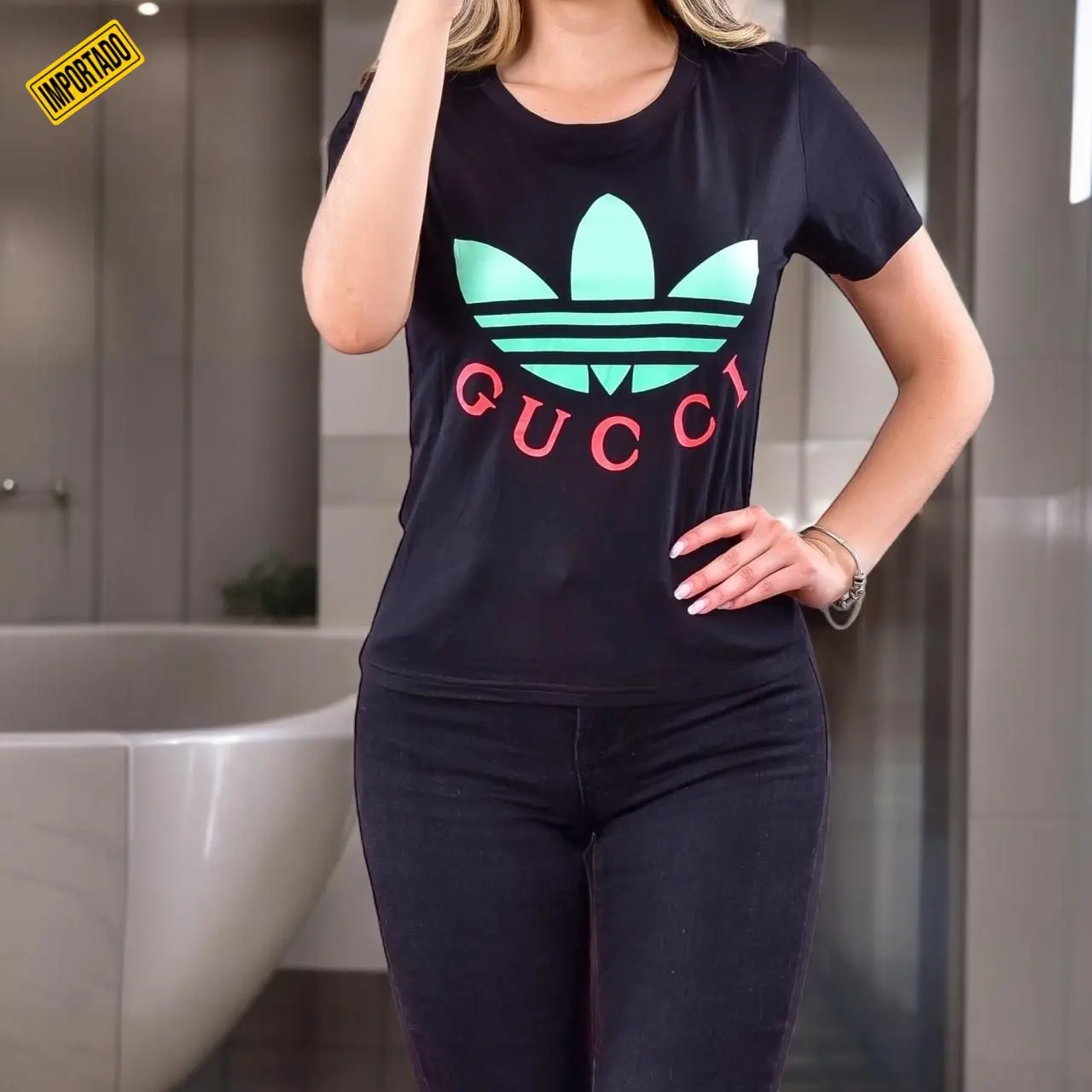 Camisa negra casual de manga corta con estampado verde menta y letras rojas, combinada con pantalones oscuros.