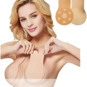 Mujer rubia aplicando par de sujetadores adhesivos color piel con diseño de orejas de conejo para levantamiento de busto sin tirantes