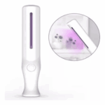 Lámpara UV portátil blanca para desinfección de superficies, con detalle de su luz morada eliminando bacterias.