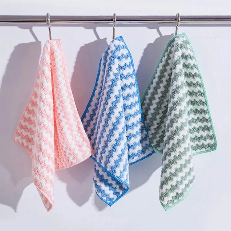 Set de 3 paños de microfibra colgando de una barra, en colores rosa, azul y verde con textura acanalada en zigzag.