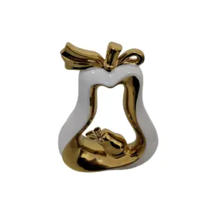Adorno de pera en cerámica blanca y dorada con diseño hueco que contiene una pequeña pera dorada en su interior.