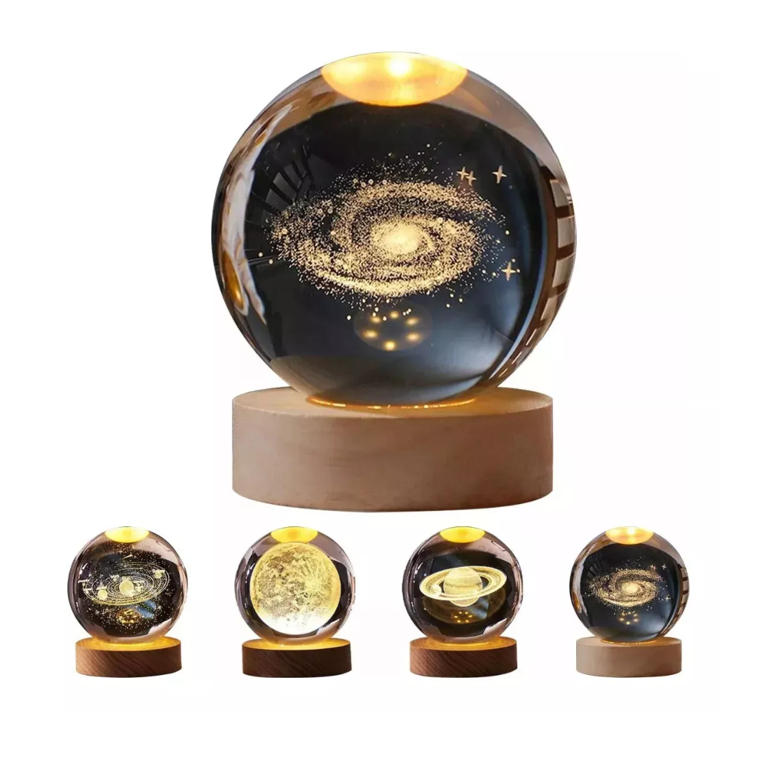 Lámpara de mesa con esfera de cristal grabada con motivos astronómicos, base de madera iluminada con luz LED cálida y conexión USB para decoración.