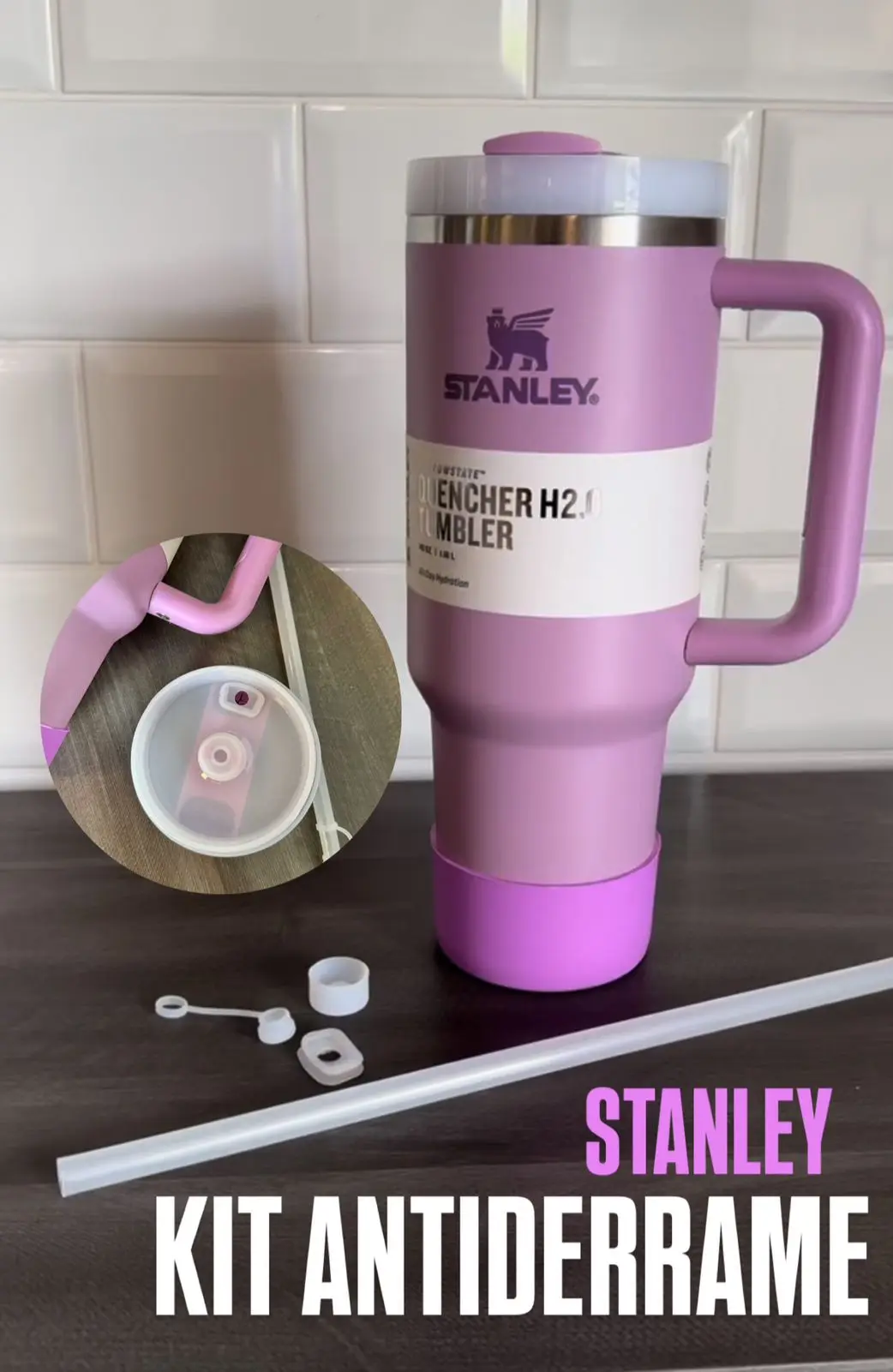 Termo Stanley violeta con asa y funda protectora, acompañado de un kit antiderrame de cinco piezas de silicona blanca y un sorbete sobre superficie oscura.