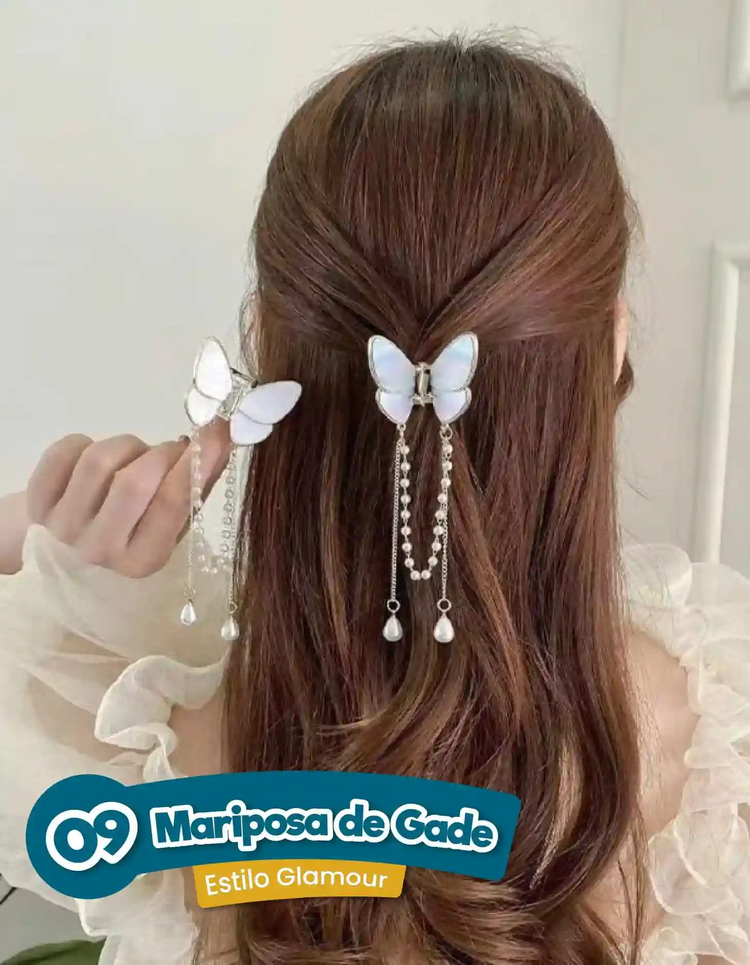 Pinza para el cabello de metal en forma de mariposa blanca con colgantes de cadenas y perlas, usada en un semirecogido.