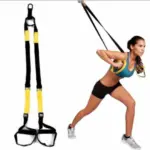 Sistema de entrenamiento en suspensión TRX negro y amarillo con asas y anclaje, mostrado junto a mujer usándolo para ejercicios de pecho.