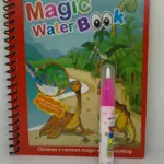 Libro espiralado rojo con portada de dinosaurios, acompañado de un rotulador rosa con punta blanca y tapa transparente sobre superficie blanca.