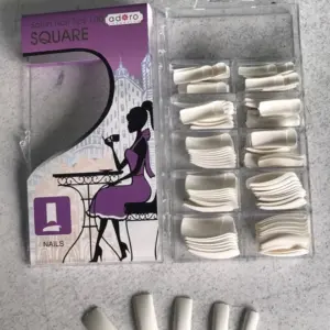 Caja de 100 uñas postizas cuadradas Adoro, color blanco, con estuche organizador transparente y cinco muestras de diferentes tamaños dispuestas abajo.