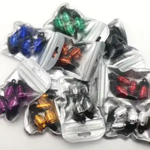 Set de tapaválvulas metálicos para llantas con diseño de granada en diversos colores, empacados individualmente en bolsas plásticas plateadas.
