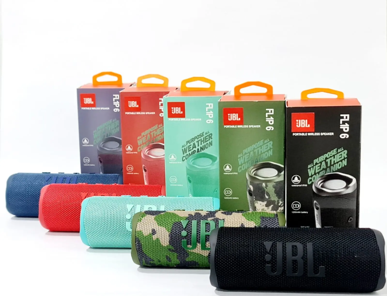 Cinco parlantes JBL Flip 6 en colores azul, rojo, turquesa, camuflaje y negro, cada uno junto a su caja de empaque respectiva sobre superficie blanca.