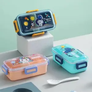 Tres fiambreras infantiles rectangulares con tapa transparente y cierres laterales, diseños de astronauta, unicornio y dinosaurio, incluyen cuchara blanca.