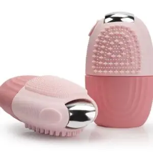 Cepillo exfoliante facial de silicona rosa con textura de puntos y punta metálica, presentado en ángulos vertical y lateral.