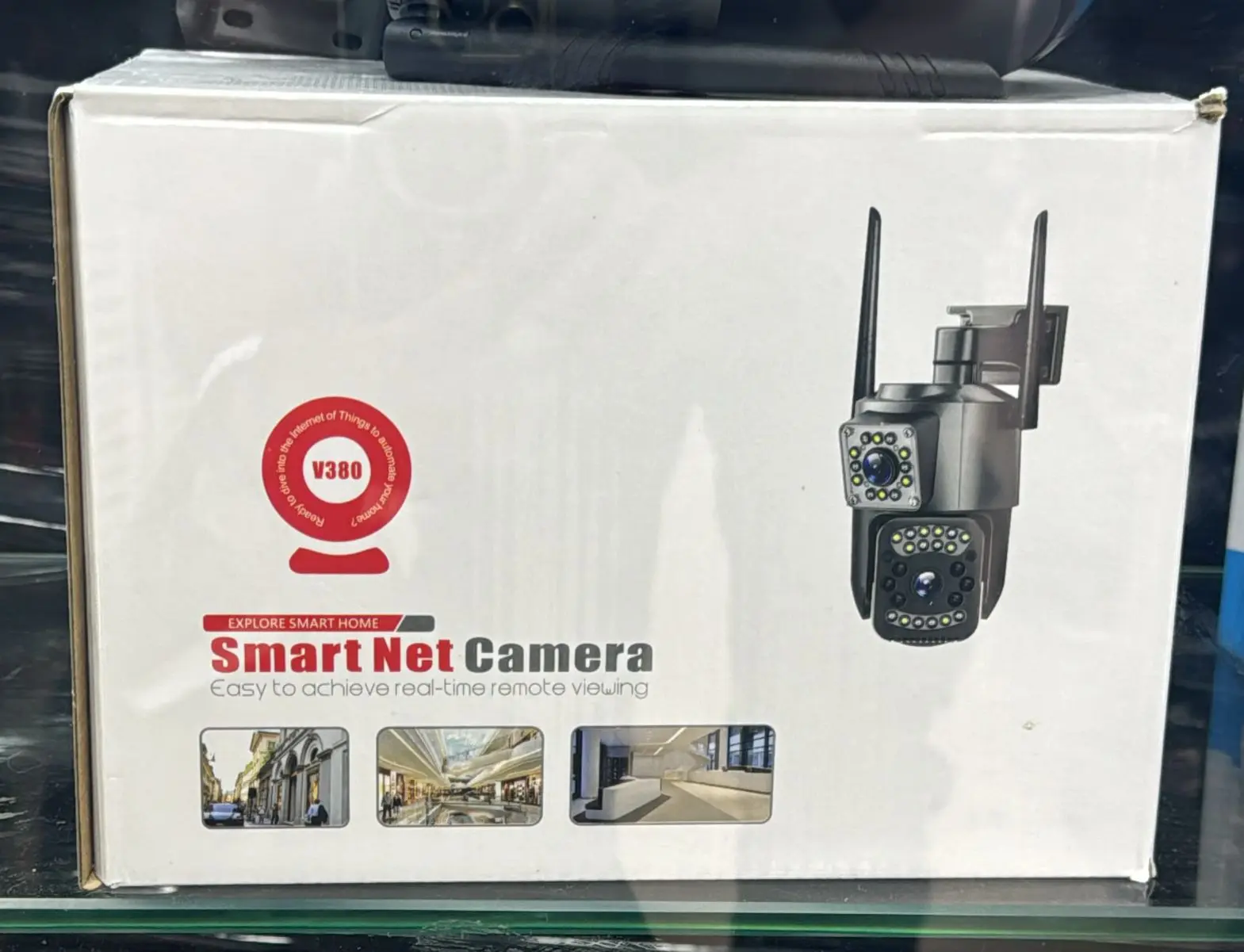 Caja blanca de Smart Net Camera V380 con de cámara PTZ de doble lente gris, dos antenas y luces LED frontales.