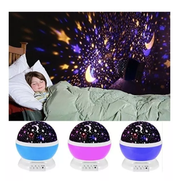 Proyector LED de estrellas esférico con base de color en tonos celeste, rosa y morado, iluminando una habitación infantil con cielo nocturno proyectado en la pared mientras un niño duerme.