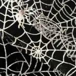 Tela negra de disfraz para niñas con diseño estampado de telarañas plateadas brillantes y pequeñas arañas blancas.