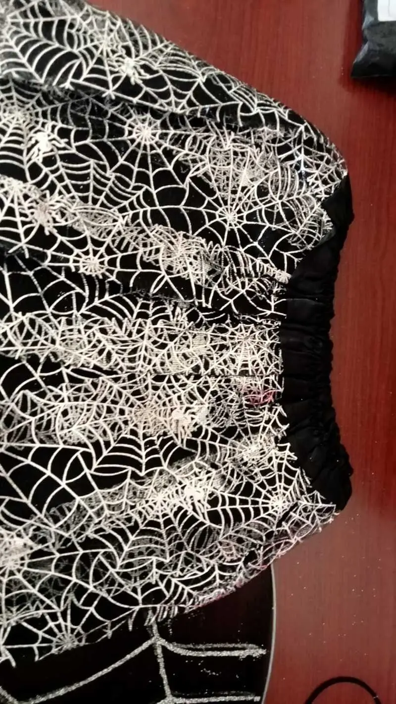 Tutú negro brillante para niña con estampado metalizado de telarañas blancas y cintura elástica fruncida.