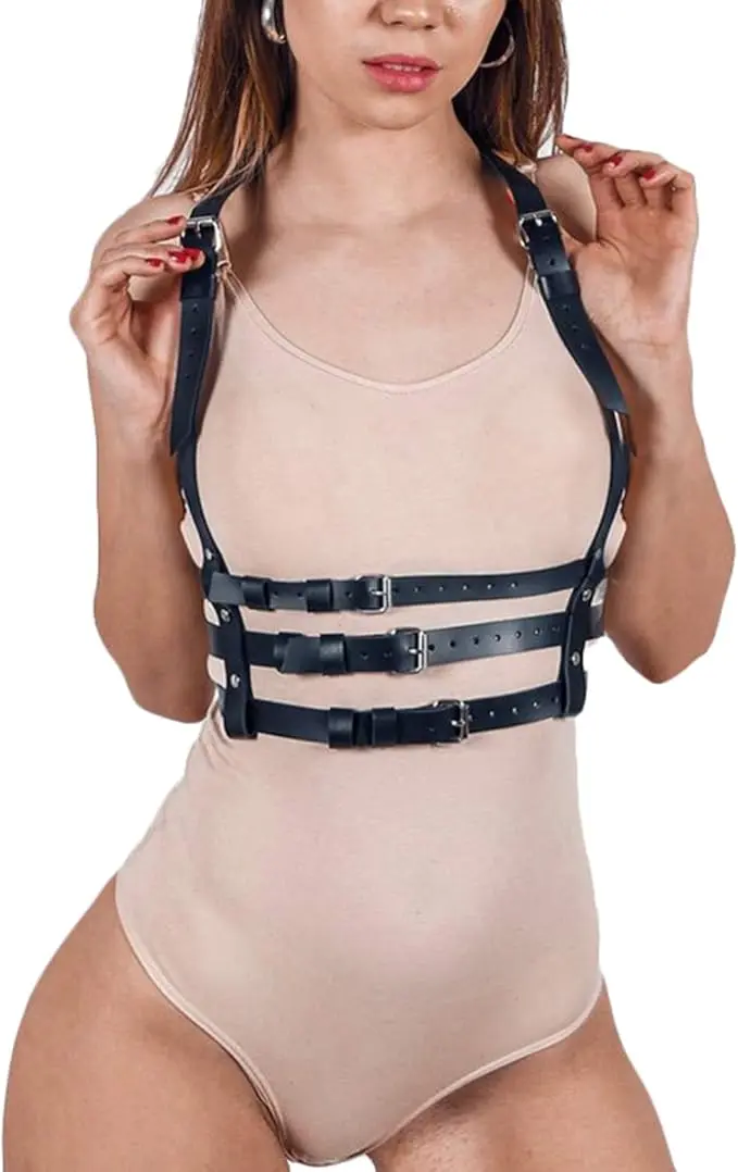 Arnés negro de cuero sintético con tres correas horizontales ajustables y hebillas metálicas, sobre body nude.