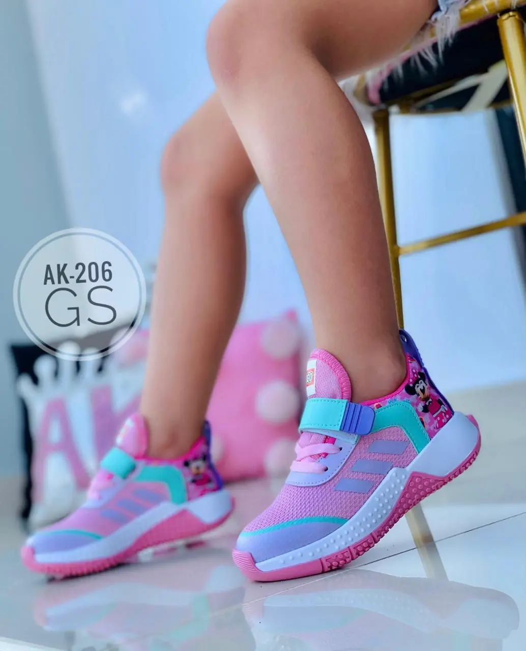 Zapatillas deportivas infantiles lila, rosa y turquesa con detalles de Minnie Mouse, velcro, suela texturizada y material sintético.