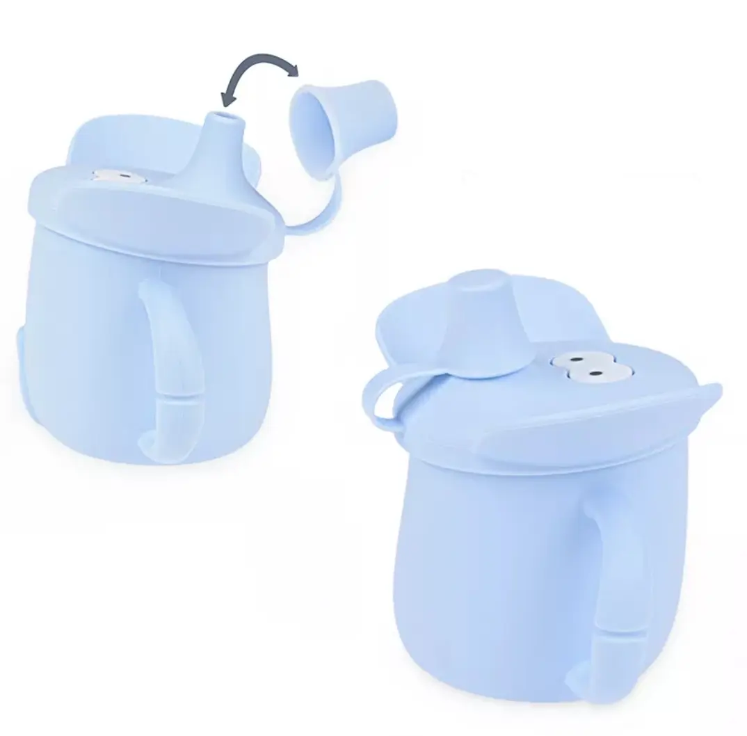 Vaso de aprendizaje de silicona azul claro con diseño de elefante y dos asas. Muestra la tapa con trompa móvil en posición abierta y cerrada.