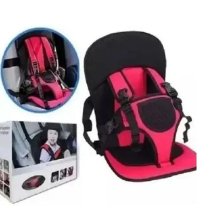 Silla de viaje para niños en rosa y negro con arnés de seguridad, mostrada con su empaque y vista de uso en un automóvil.