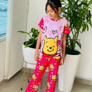 Pijama infantil de dos piezas fucsia y lila con estampado de Winnie the Pooh, elaborada en tela suave para descanso.