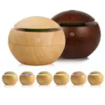Humidificador difusor ultrasónico esférico con textura de madera clara y oscura, mostrando seis variantes de luz LED de colores.