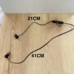 Auriculares inalámbricos deportivos negros Bluetooth con micrófono, con medidas de 21 cm y 41 cm en superficie de madera.