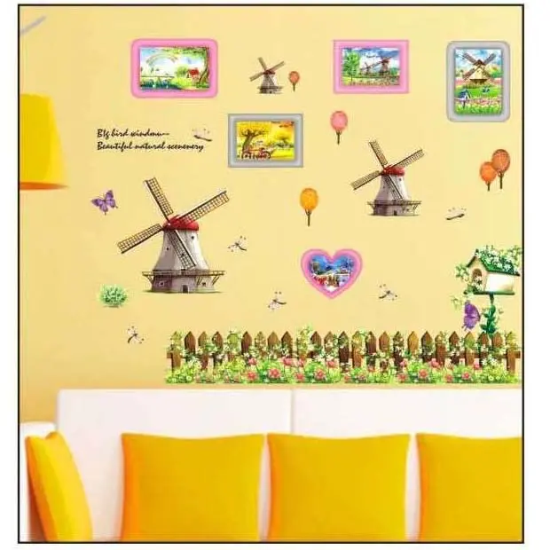 Set de stickers decorativos en PVC para pared con diseño de molinos, paisajes campestres, flores y una cerca de madera sobre fondo amarillo.