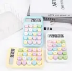 Tres calculadoras de oficina en tonos pastel azul, amarillo y blanco con botones redondos grandes, sobre fondo blanco con libros.