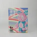 Caja de bloques de construcción 3D diseño osito coleccionable con figura colorida de tonos rosados y azules.