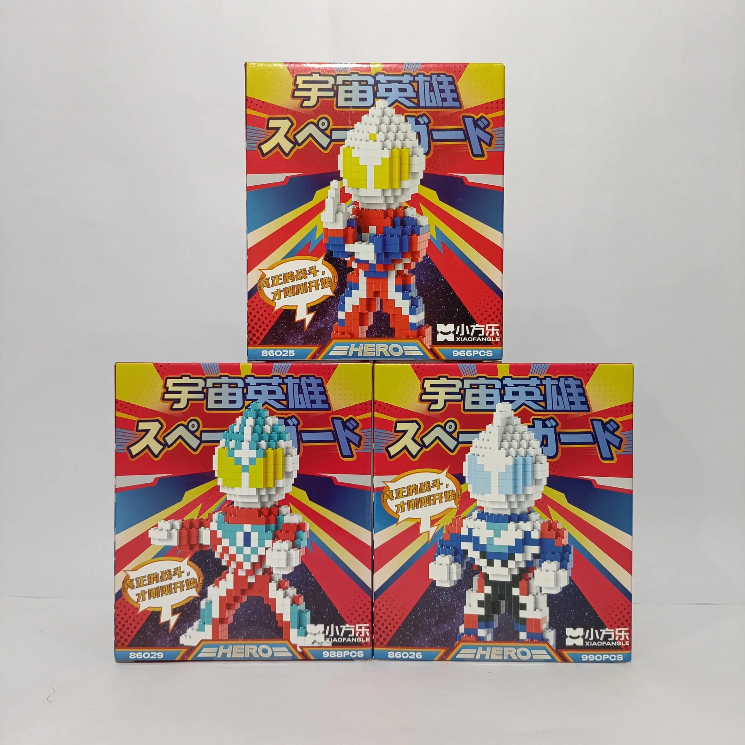 Tres cajas de figuras de construcción tipo Megaman con variantes en rojo, azul y blanco, apiladas en pirámide sobre fondo blanco.