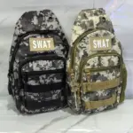 Dos bolsos pecheros camuflados digitales con parche SWAT, en versiones oscura y clara, con múltiples compartimentos y cierres frontales.