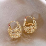 Par de aretes tipo argolla dorados con textura entrelazada y diseño tipo nido, sobre fondo de tela satinada gris.
