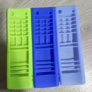 Tres fundas de silicona para control remoto LG clásico en colores verde claro, azul y lila, dispuestas sobre superficie de madera.