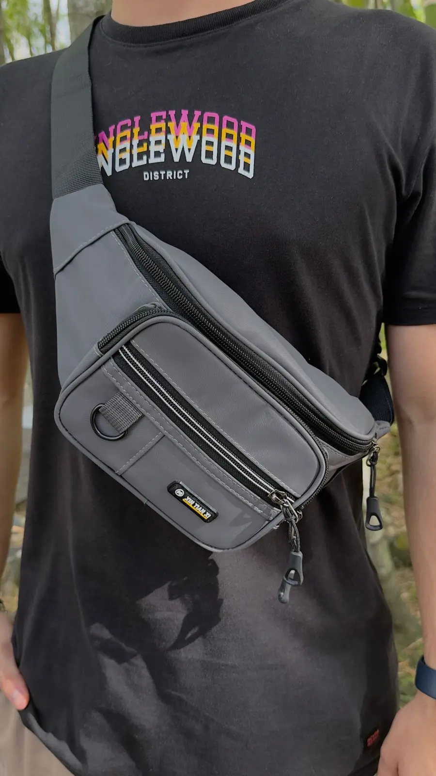 Riñonera urbana gris para hombre de material impermeable con correa ajustable, múltiples compartimentos con cierre de cremallera y bolsillo frontal con llavero de argolla en D.