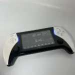 Consola portátil Play X con diseño ergonómico en negro y blanco, pantalla HD con menú de juegos y luces LED azules en los laterales.