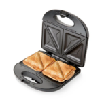 Sanduchera negra de dos puestos con placas antiadherentes fijas, abierta y con dos sándwiches dorados y triangulares listos para servir.
