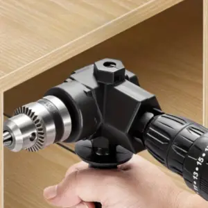 Adaptador de taladro angular negro de 90 grados acoplado a un taladro inalámbrico perforando una esquina estrecha en mueble de madera.