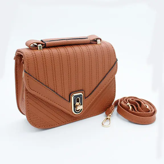 Bolso bandolera marrón de mano en material sintético con textura granulada, solapa frontal en V, cerradura metálica dorada y correa ajustable enrollada al lado.