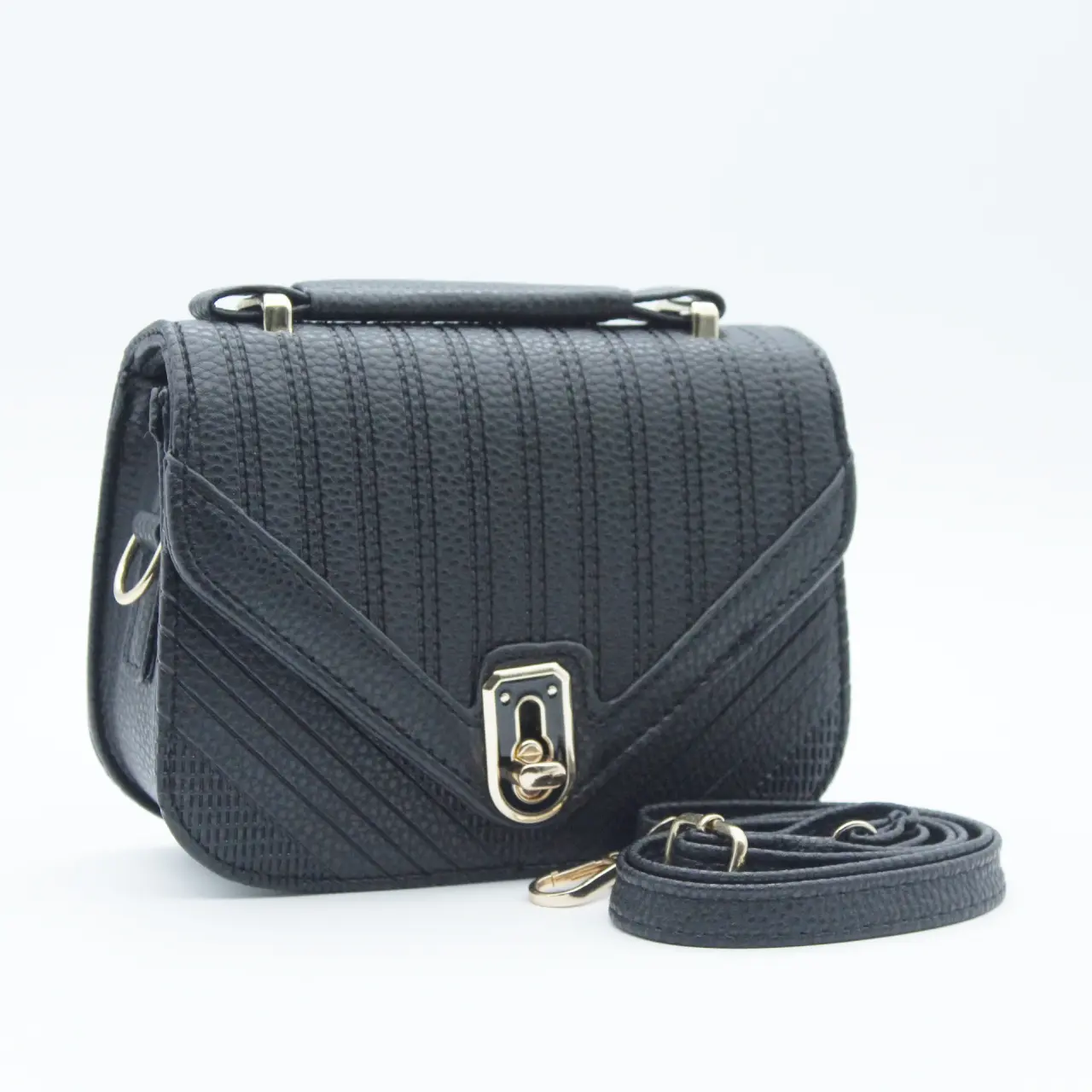 Bolso bandolera negro de mano sintético, con solapa frontal texturizada, herrajes dorados y correa ajustable enrollada al lado.