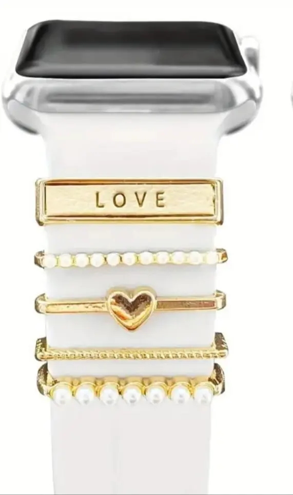 Pasadores dorados para correa de smartwatch blanca con detalles de perlas, un corazón y la palabra LOVE grabada en acero inoxidable.