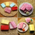 Cajas de regalo rectangulares para joyería en varios colores y texturas, algunas abiertas con interior blanco y lacitos decorativos.