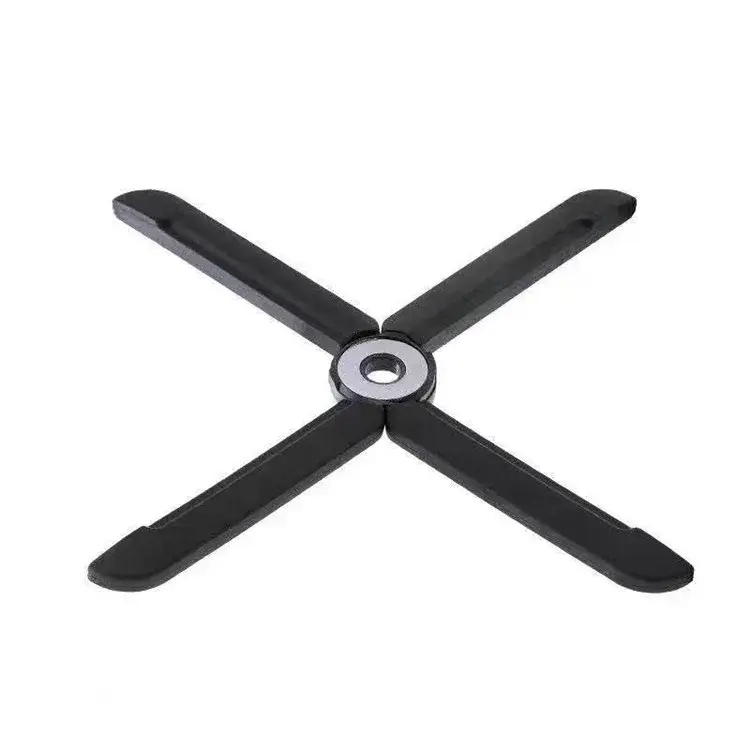 Salvamantel térmico plegable negro con diseño en X y centro metálico plateado para proteger superficies de ollas y sartenes.