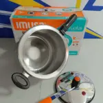 Olla a presión Imusa Secury Plus de 7 litros en aluminio con cuerpo plateado, tapa superior con asa naranja y caja de empaque al fondo.