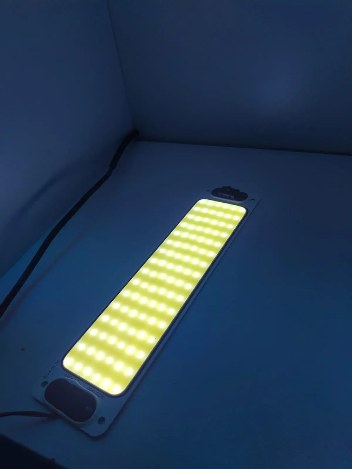 Plaqueta de techo LED rectangular para habitáculo de vehículo con múltiples puntos de luz blanca, vista sobre superficie oscura.